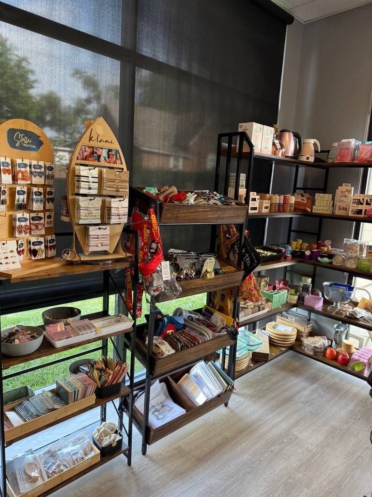 Shelves of handmade jewelry, bracelets, soaps, candles, and gifts from local makers at SereniTea Boutique