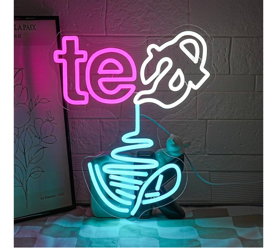 Neon sign at SereniTea Boutique with a white teapot pouring into a glowing aqua teacup spelling the word tea