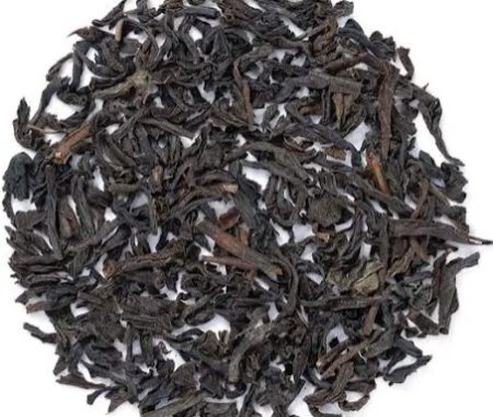 Circle of dark decaf black tea loose leaves on a white background at SereniTea Boutique