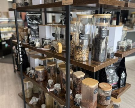 Shelves of loose leaf tea jars with chalkboard labels inside SereniTea Boutique in Lee's Summit