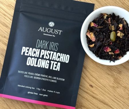 Peach pistachio oolong tea pouch beside a bowl of the loose leaf blend with rose petals at SereniTea Boutique