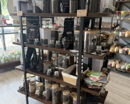 Wooden shelf of loose leaf tea jars and specialty tea pouches at SereniTea Boutique in Lee's Summit