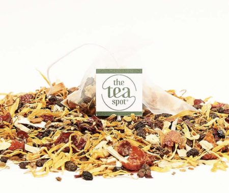 Wellness tea sachet resting on a blend of marigold petals, rose hips, and berries at SereniTea Boutique
