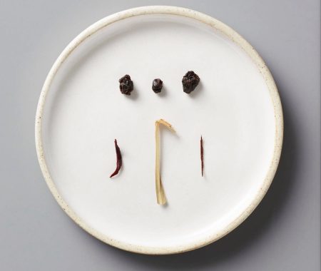 Dried berries, hibiscus petals, and lemongrass arranged on a ceramic plate at SereniTea Boutique